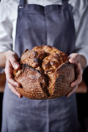Bäcker hält Brot in der Hand